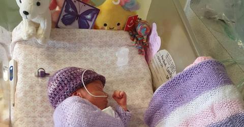 Purple butterfly sticker sits next to a newborn.