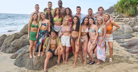 Bachelor in Paradise Season 9 cast stands on rocks on the beach