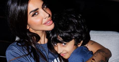 Sara Al Madani holding her son Maktoum in her arms as they both smile at the camera