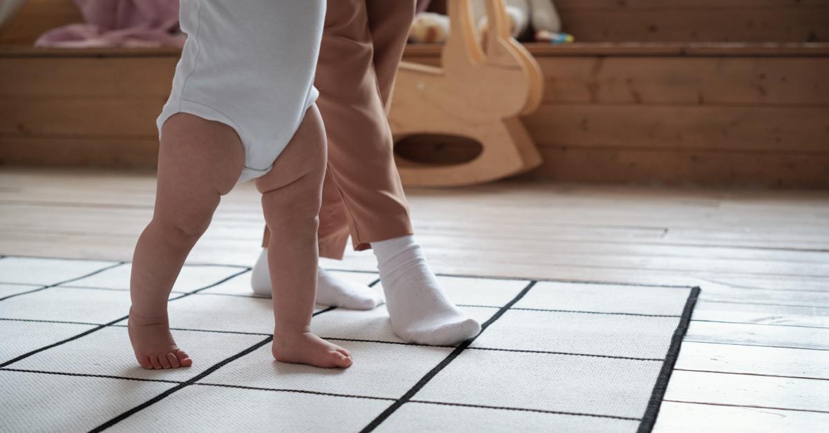 A parent teaching their baby to walk.