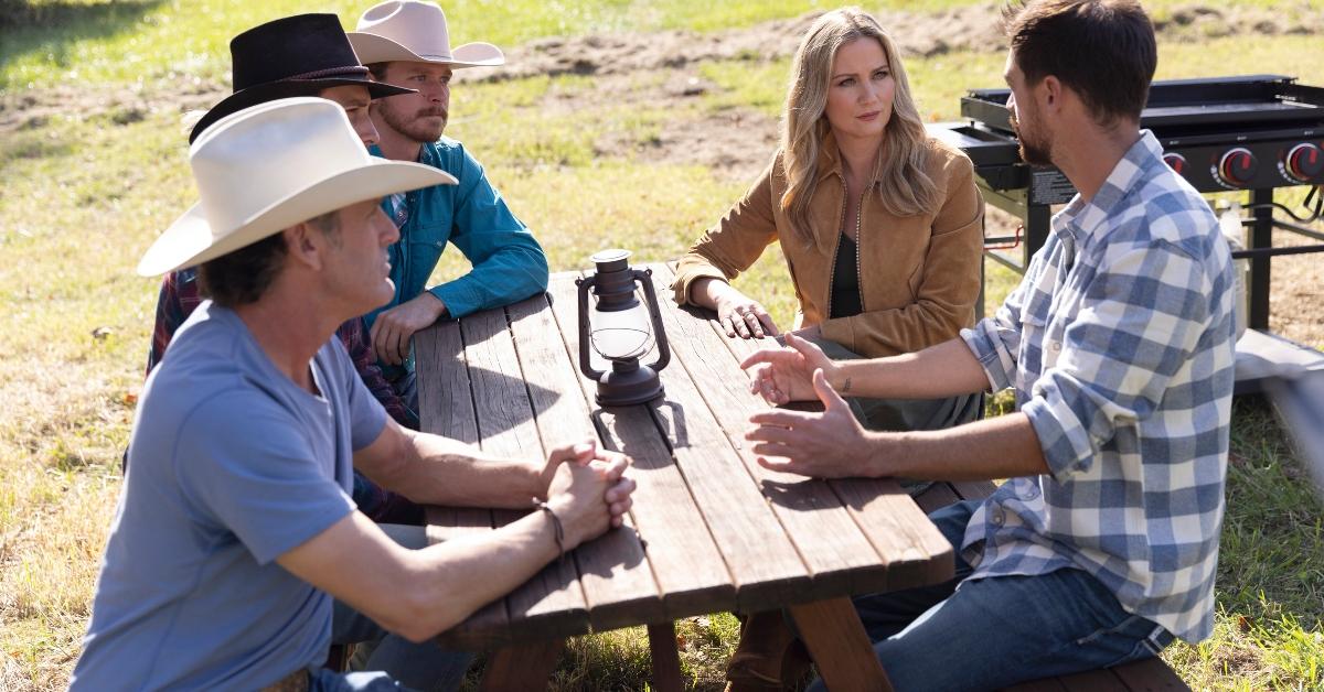 The Season 2 Farmer Wants a Wife guys with host Jennifer Nettles at a picnic table.