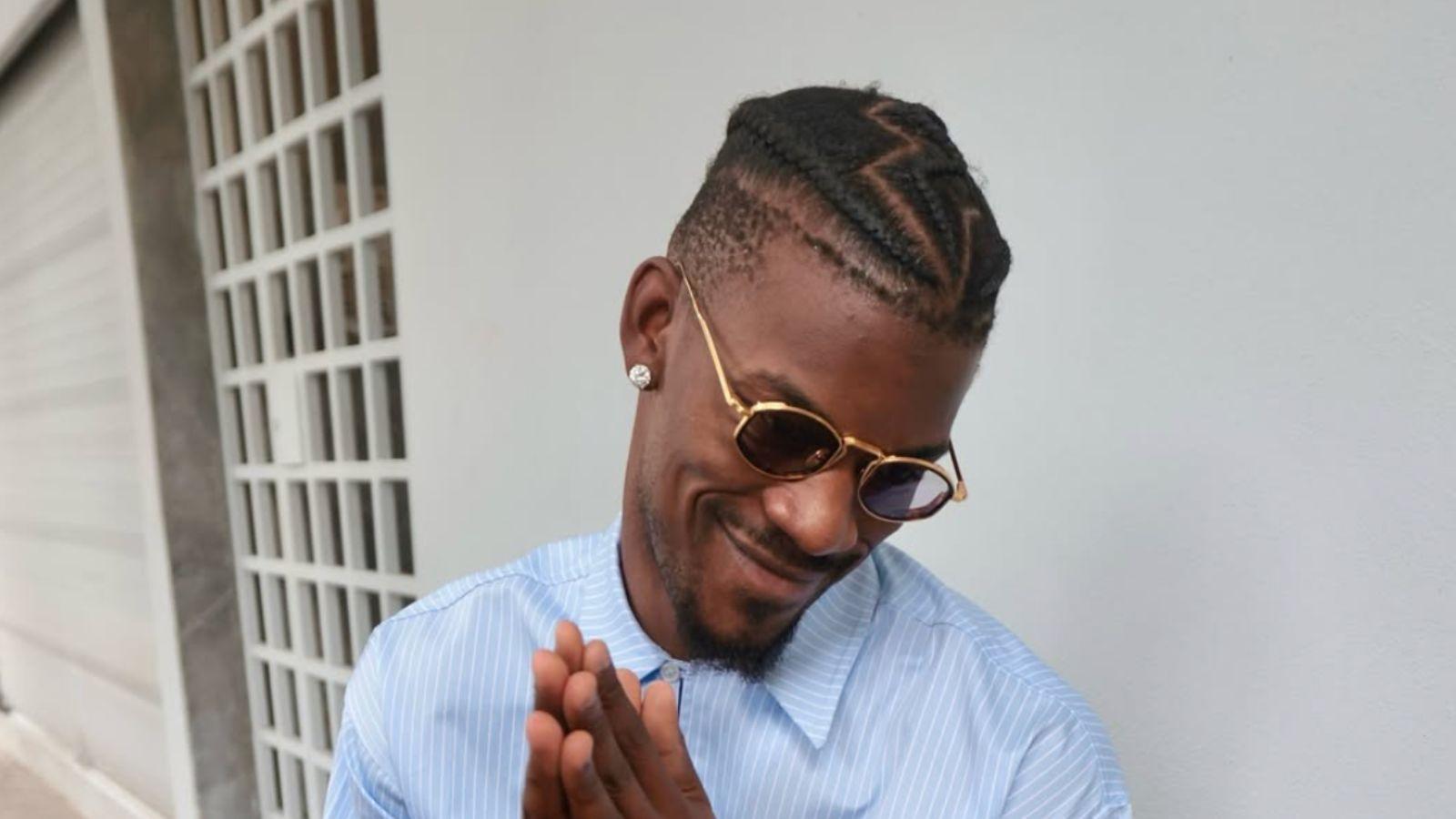 Jimmy Butler looking at a cup of coffee in sunglasses. 