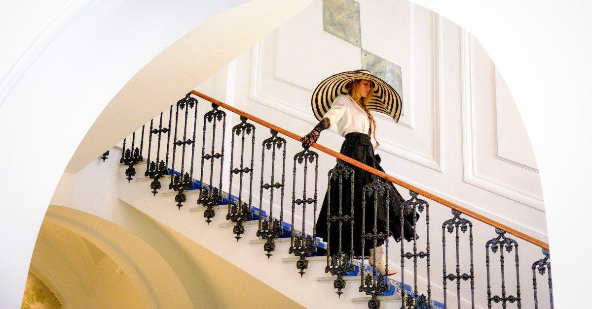 Emily walking down the stairs in 'Another Simple Favor'.