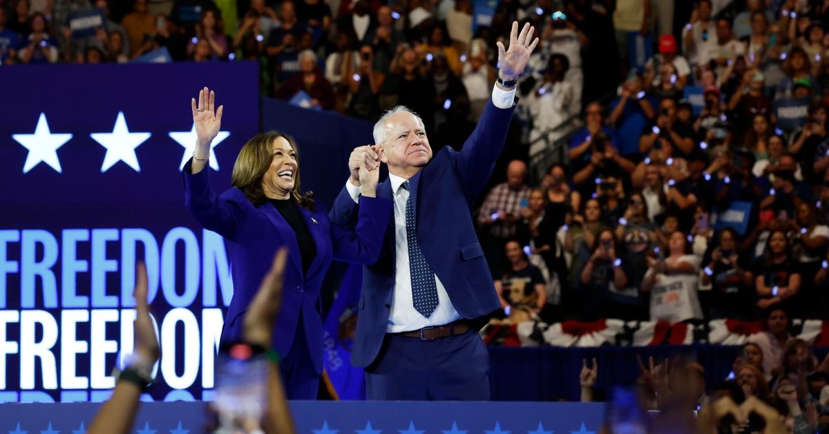 Kamala Harris and Tim Walz clasp hands onstage after the end of a campaign rally on Aug. 20, 2024, in Milwaukee.