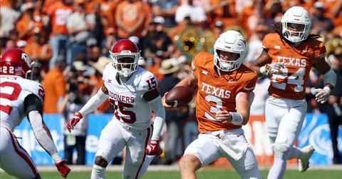 Quarterback Quinn Ewers #3 of the Texas Longhorns runs the ball as he is pursued by Kendel Dolby #15 of the Oklahoma Sooners at the Cotton Bowl on Oct. 7, 2023, in Dallas, Texas.