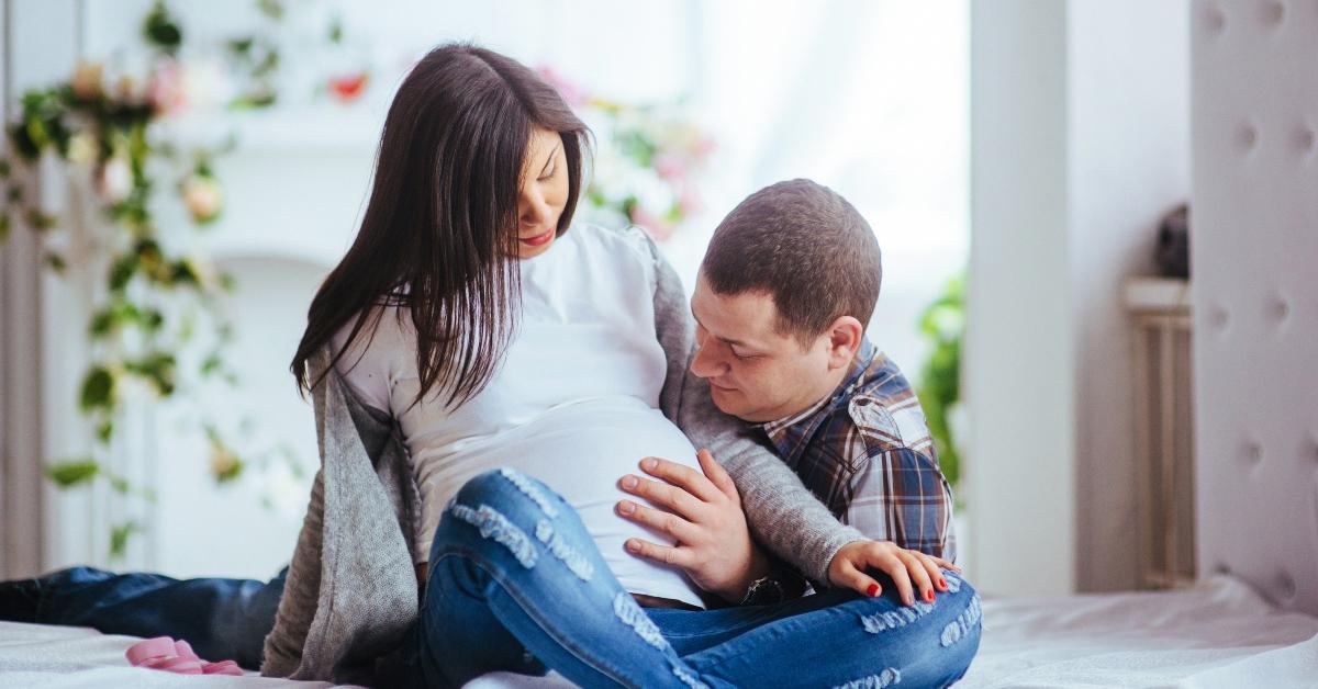 Husband cradles pregnant wife's belly