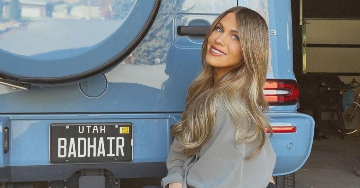 Jessi Ngatikaura kneels down in front of her Bad Hair vanity plate.