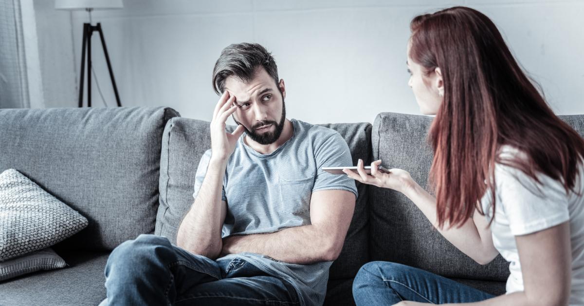 A young couple argues in their living room.