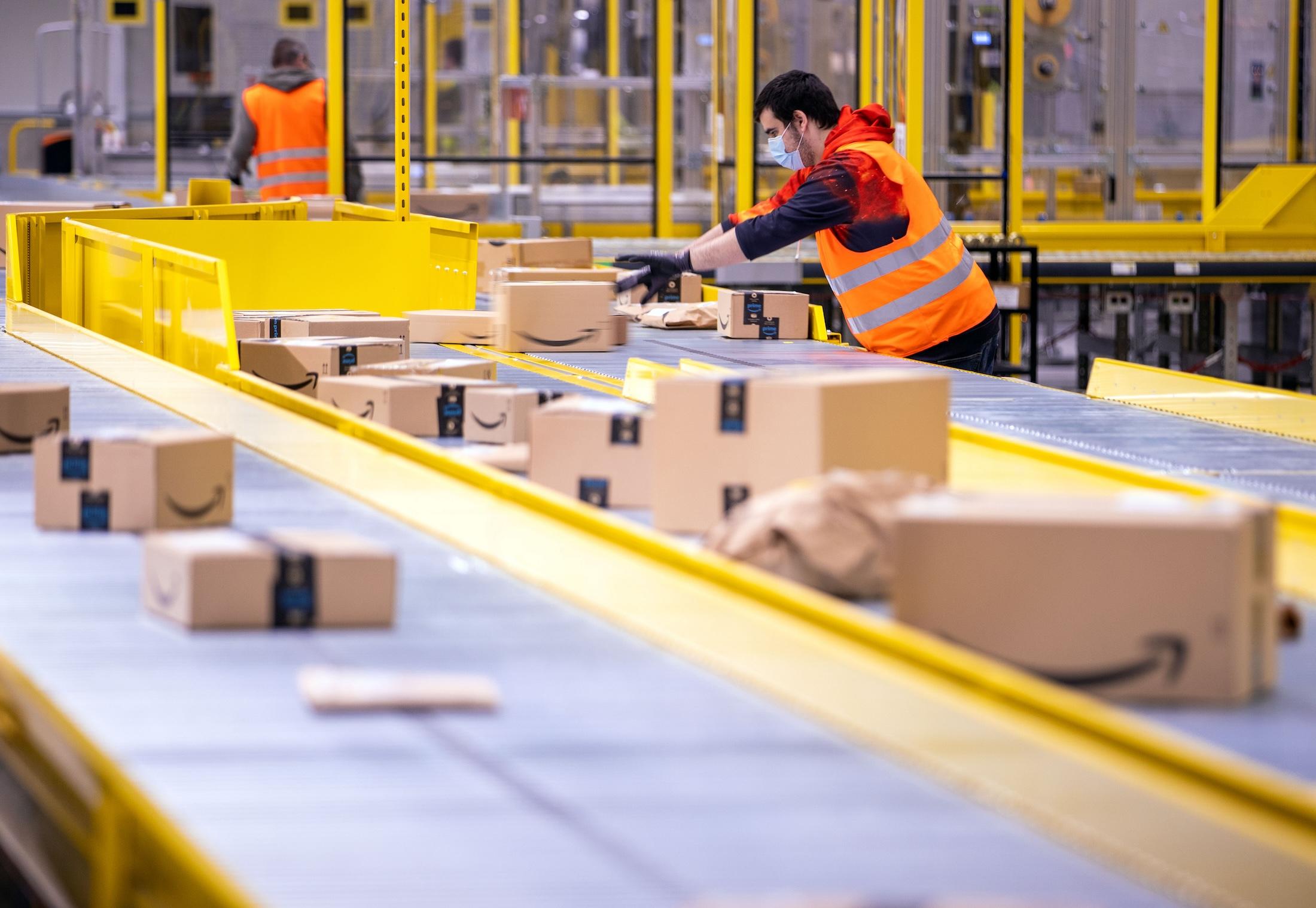 Employees sort parcels from online retailer Amazon at distribution center