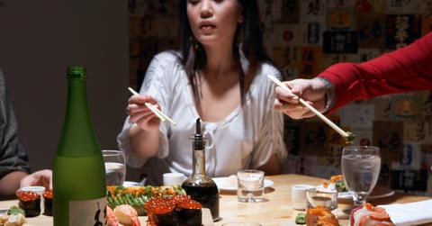 young women eating sushi in restaurant