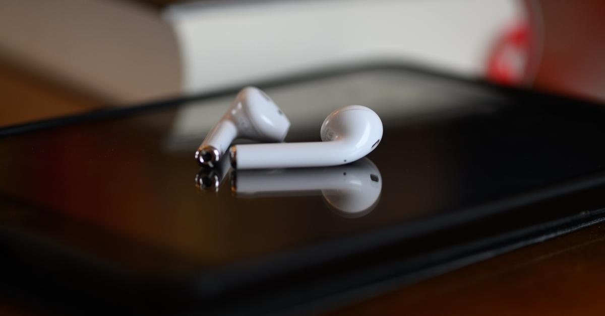 An iPad tablet with headphones is lying on a table.