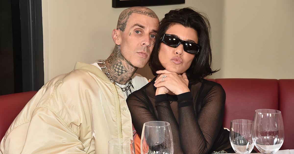 Travis Barker and Kourtney Kardashian sitting at a table together. 