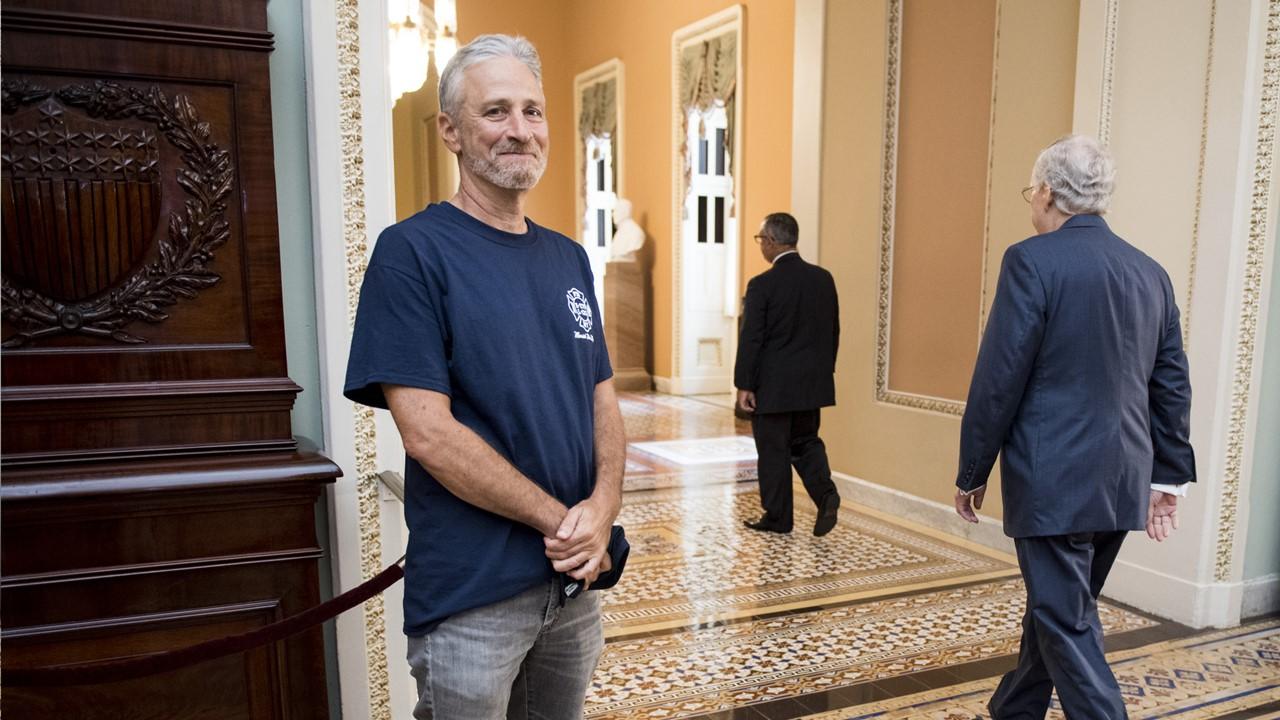 Jon Stewart smiles as Senate Majority Leader Mitch McConnell walks by at the Ohio Clock Corridor in the Capitol on July 23, 2019.