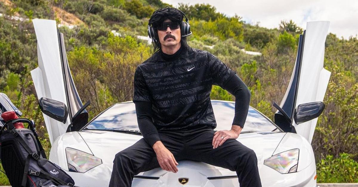 Dr DisRespect sits on the hood of a white car