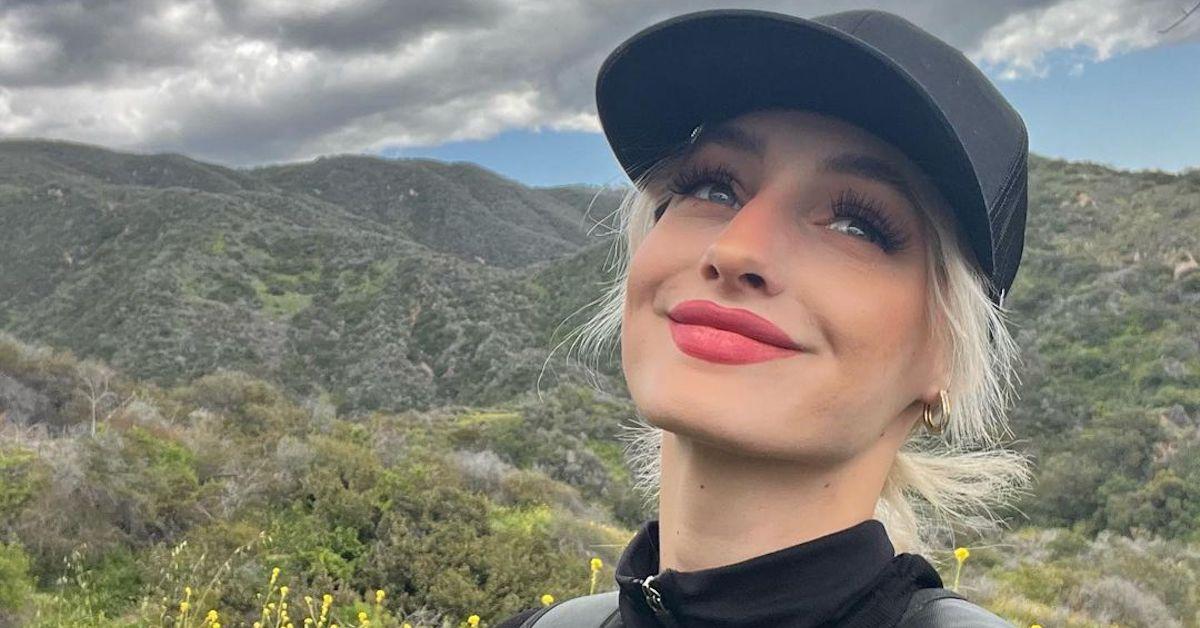 Moriah Plath smiling on a hike in lush hills