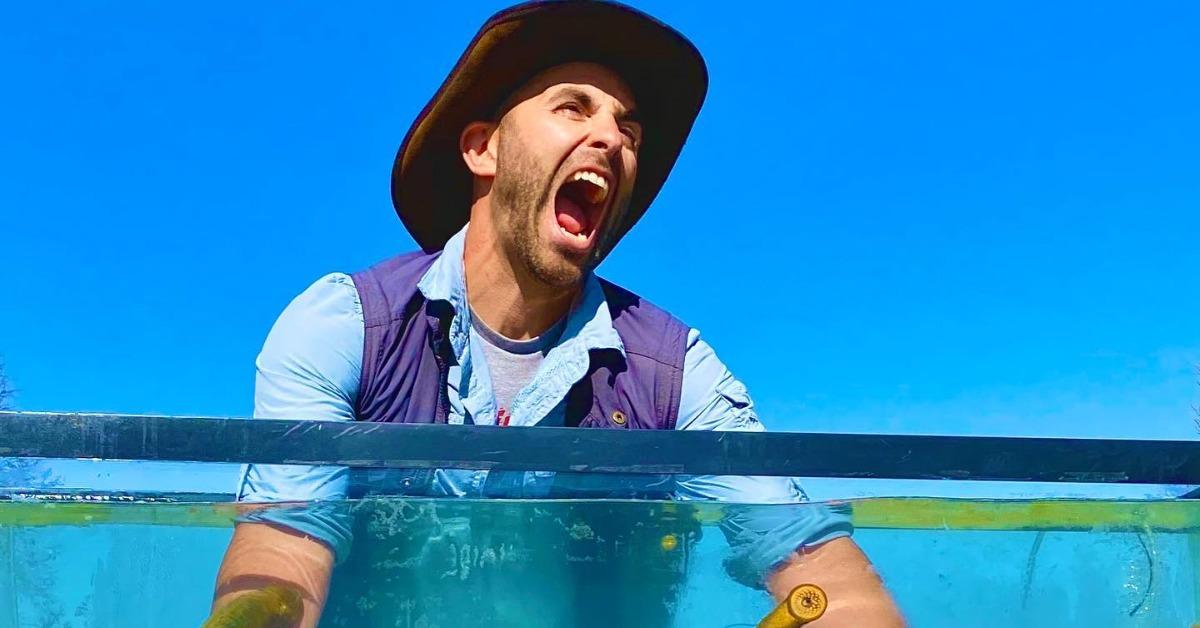 Coyote Peterson with his arms in water