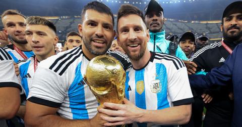 Lionel Messi and Sergio Aguero hold World Cup trophy