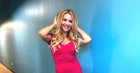 Jacey Birch in a pink dress with her hands in her hair.