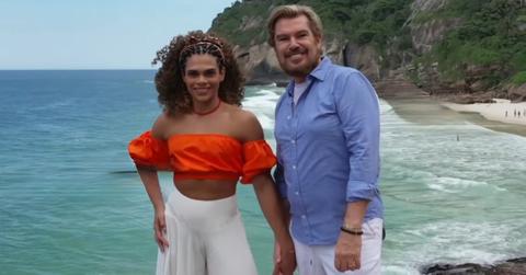 Alliya Batista and Shawn Finch smile while posing in front of the ocean in '90 Day Fiancé: Love in Paradise' Season 4.