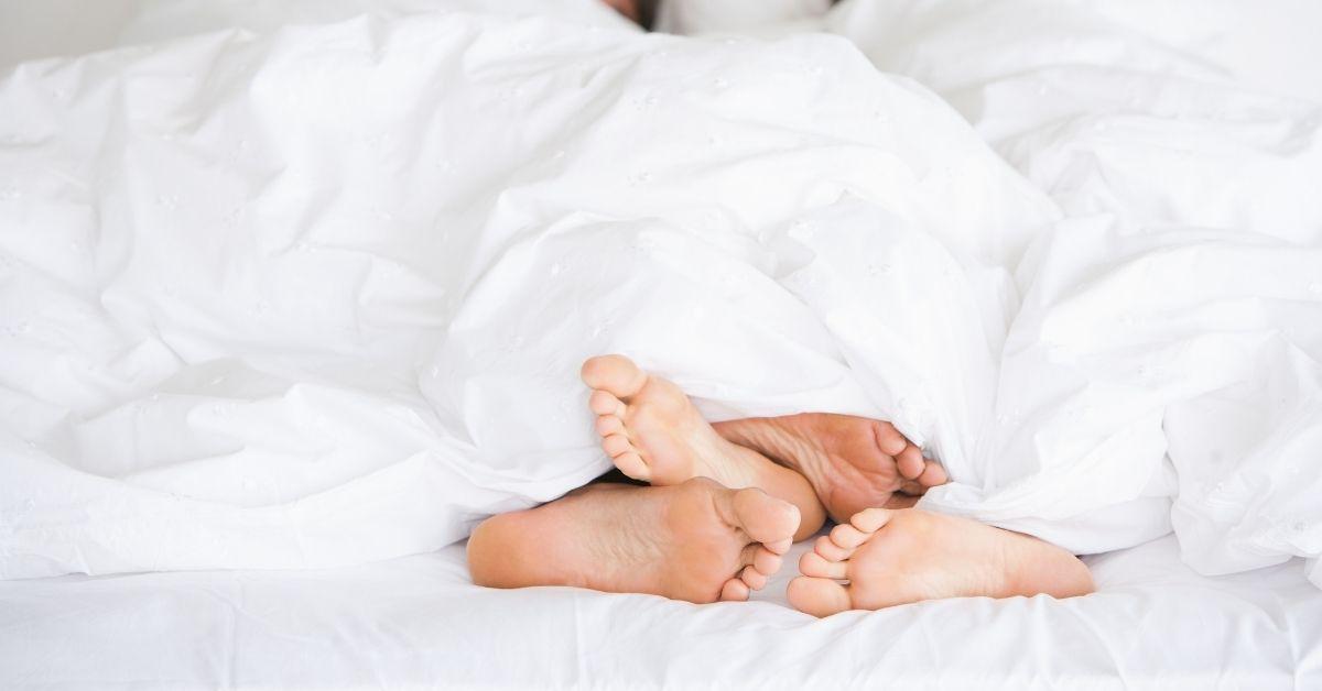 Man woman feet in bed
