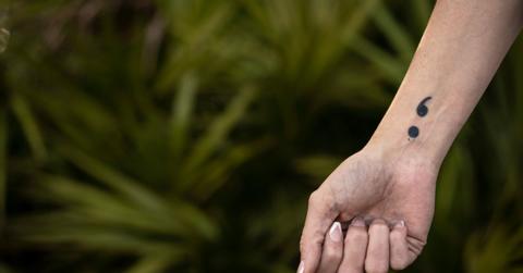 A semicolon tattoo on a woman's wrist