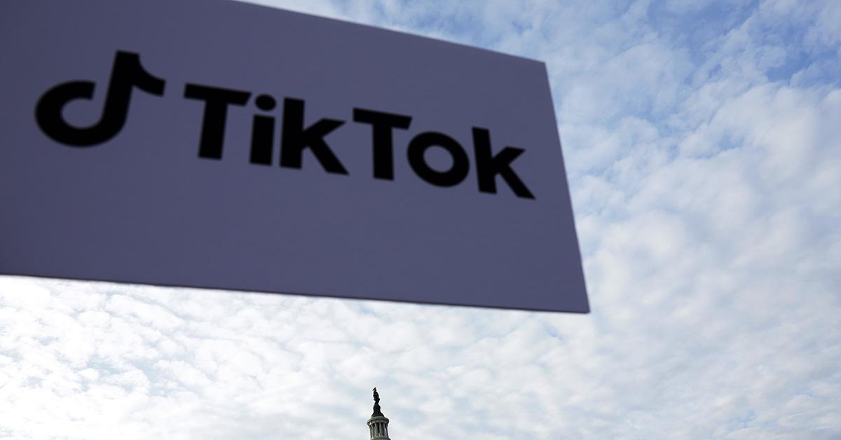 TikTok logo against a cloudy sky. 