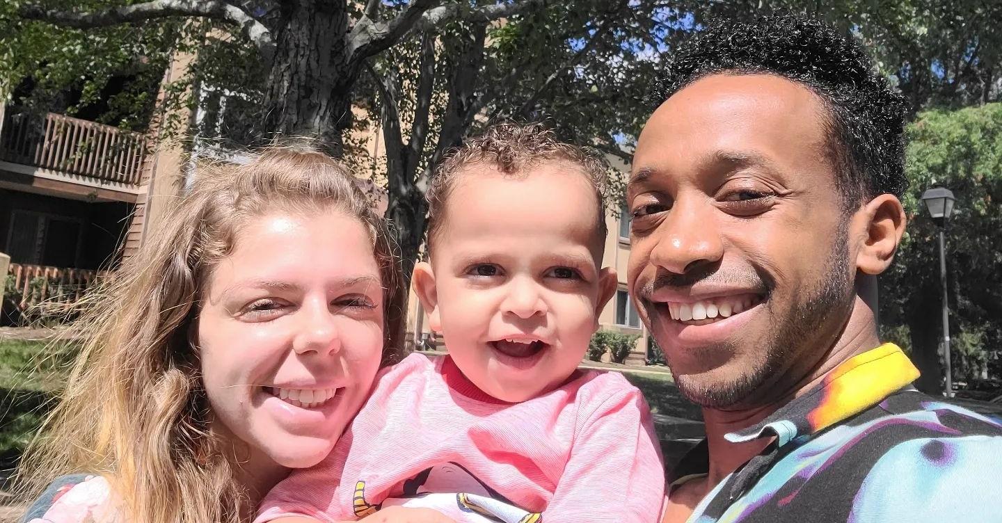 Ari Weinberg, her husband Biniyam Shibre and their son, Avi Shibre, stand outside and smile for a selfie.