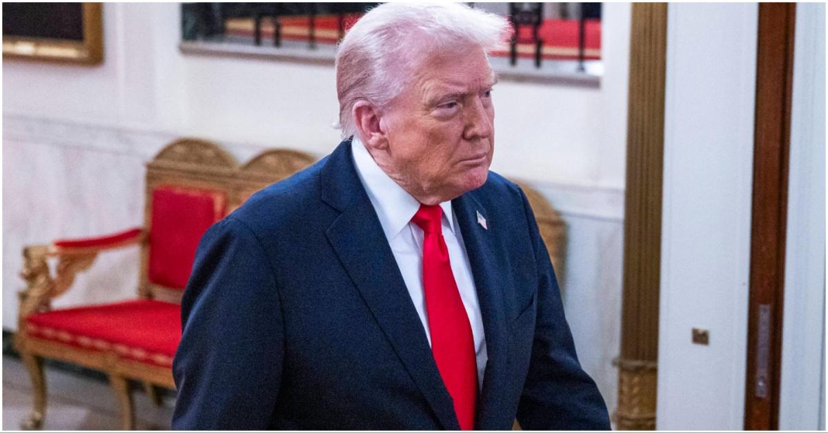 President Donald Trump walking with binder