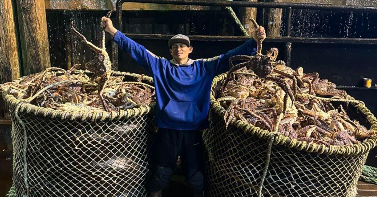 Oj Ganuelas poses in between two drums full of crabs