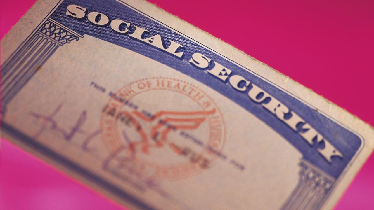 A Social Security card over a pink background