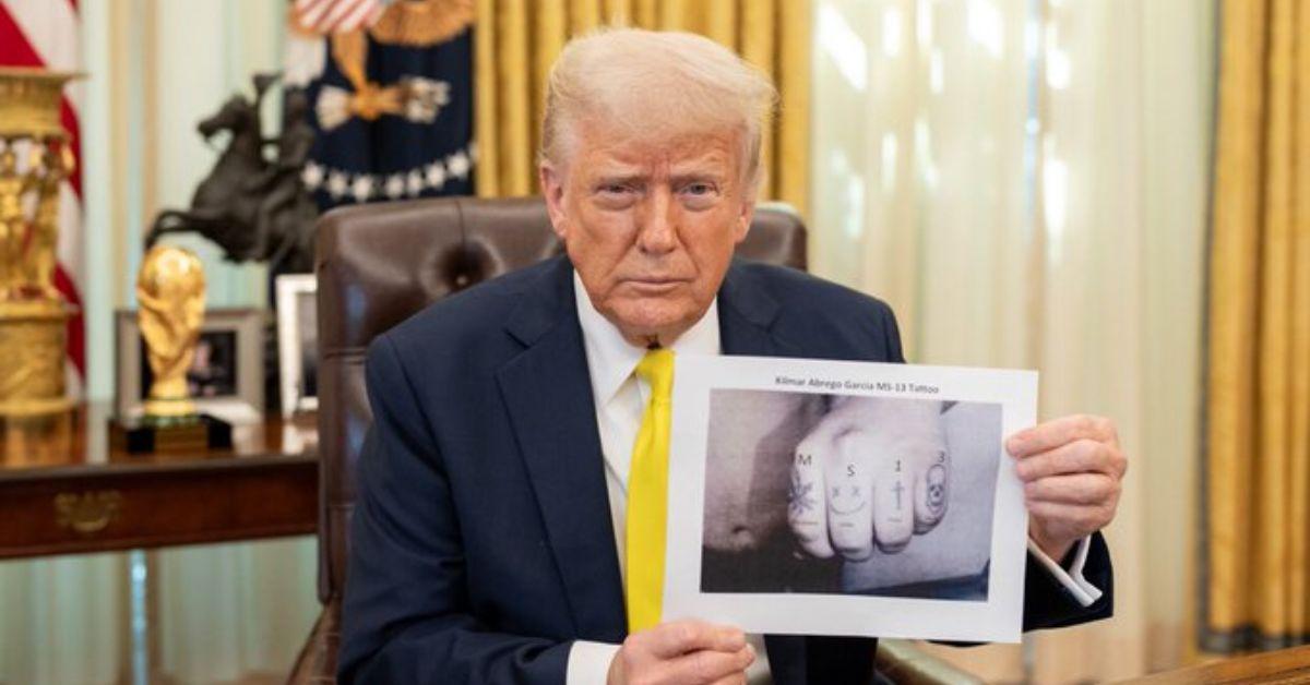 Donald Trump holding a doctored photo of Kilmar Abrego Garcia's hand. 