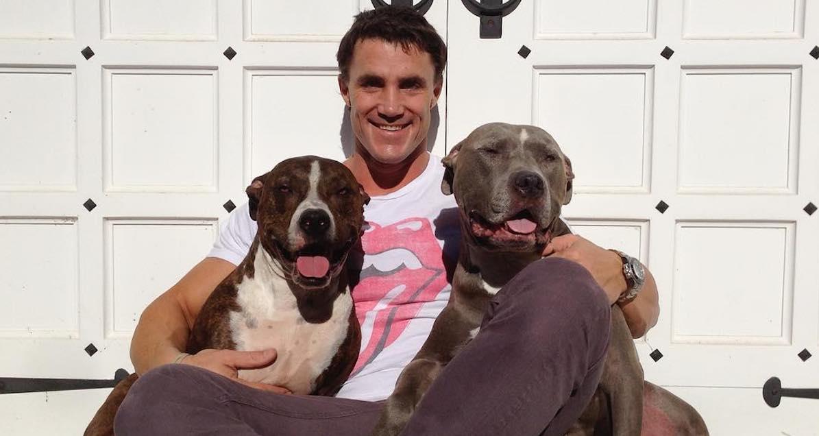 Greg Plitt posing with two dogs