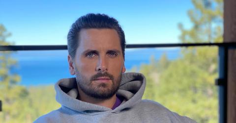 Scott Disick sitting near a lake