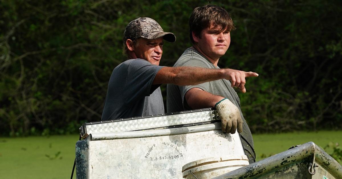 'Swamp People' cast members on a boat looking for an alligator.