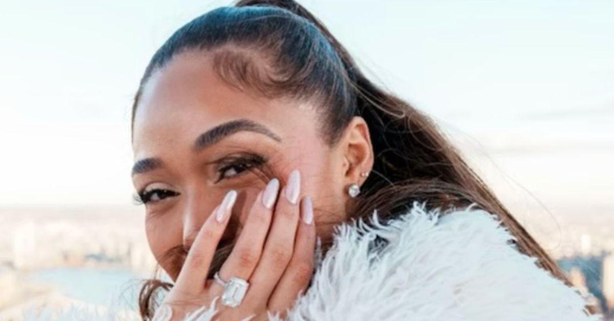 Jordyn Woods holding her hand with her engagement ring in front of her face. 