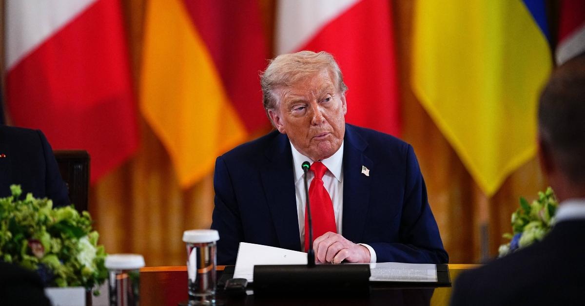 Donald Trump turns a page while speaking to heads of state from other countries in August 2025