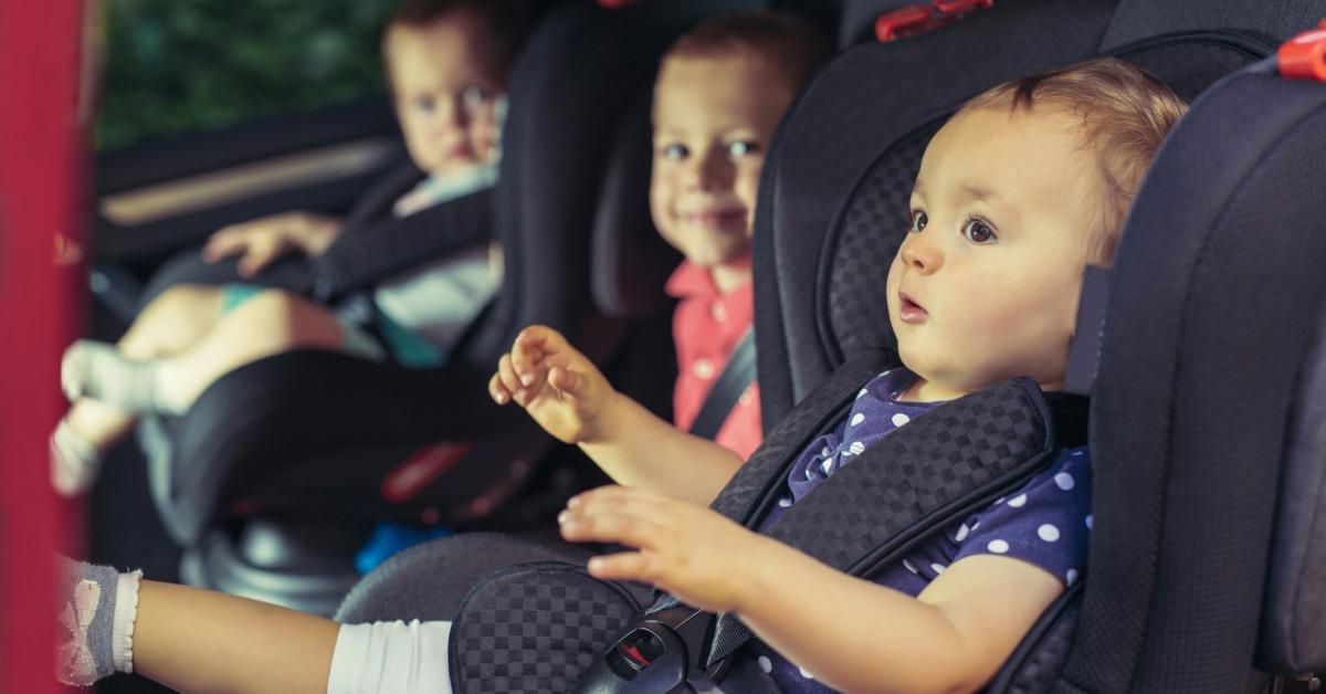 three children in car safety seat picture id