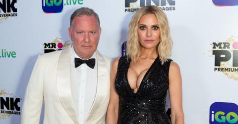 PK Kemsley in a white suite posing with Dorit Kemsley in a black dress