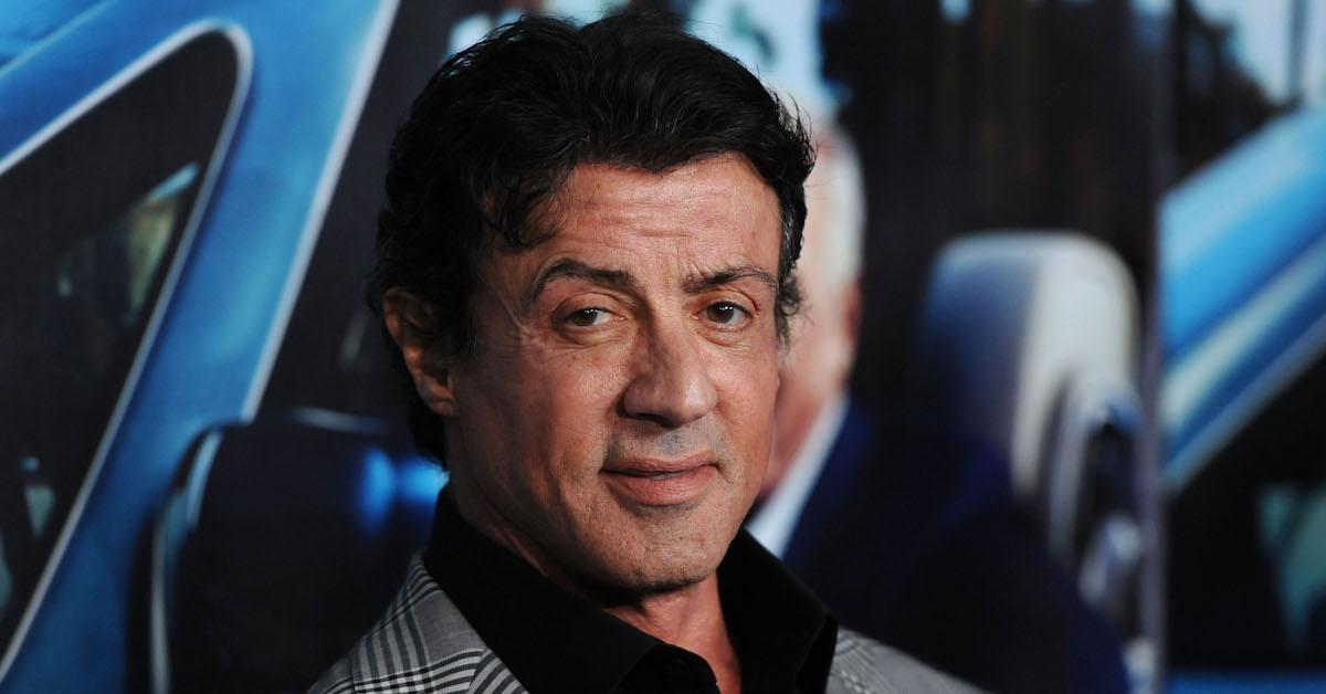 Sylvester Stallone on the red carpet against a blue background