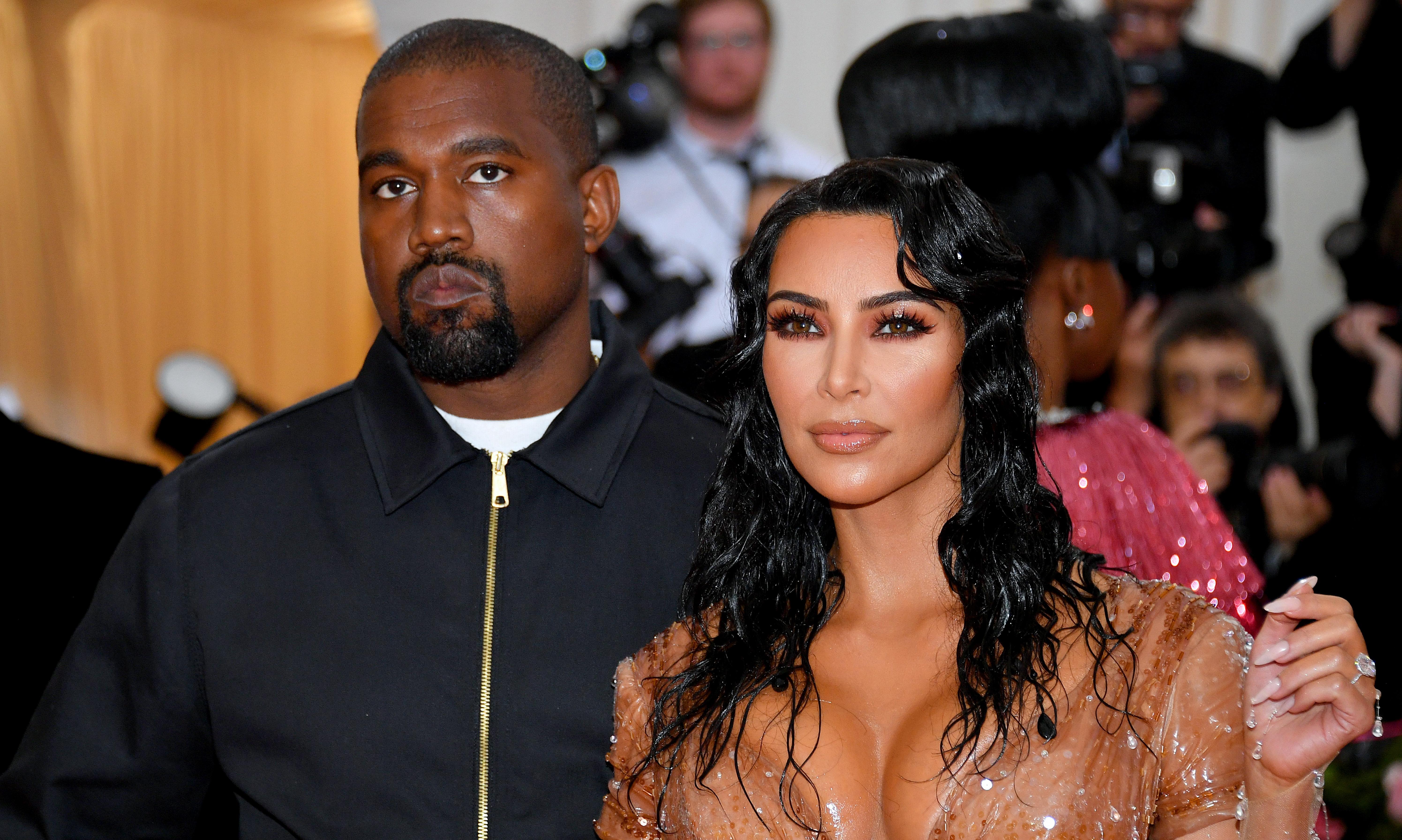 Kanye West and Kim Kardashian pose for a photo.