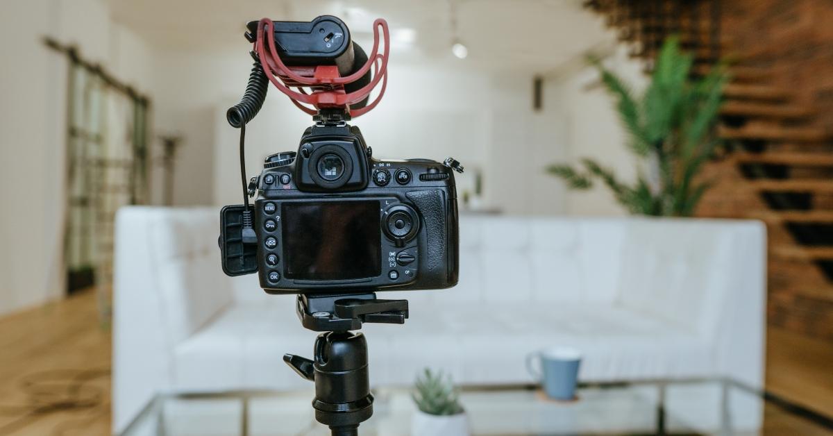 camera with microphone on the tripod ready for the video recording in the living room.