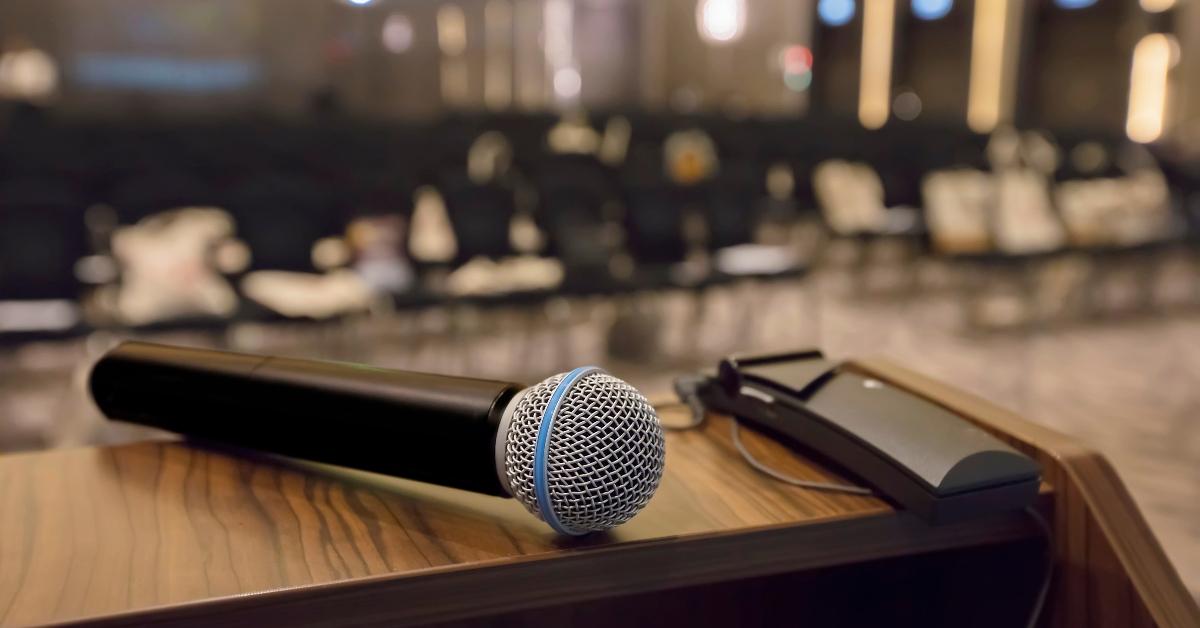 There is a microphone on the table against the background of an empty hall. - stock photo