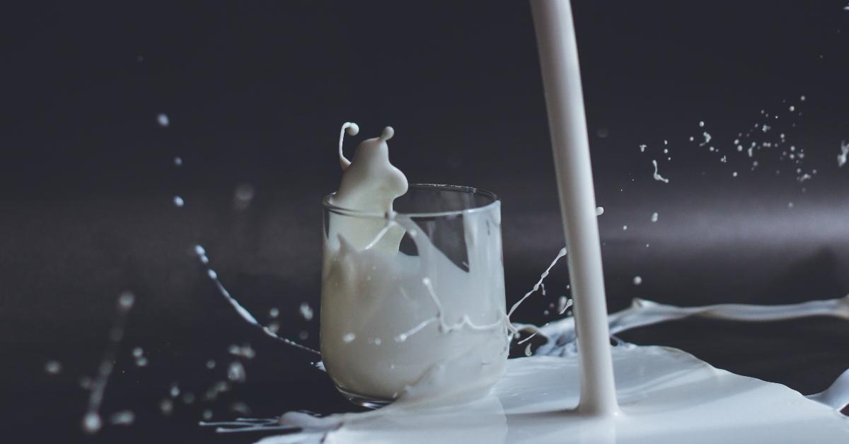 Milk being poured and missing a partially fully glass