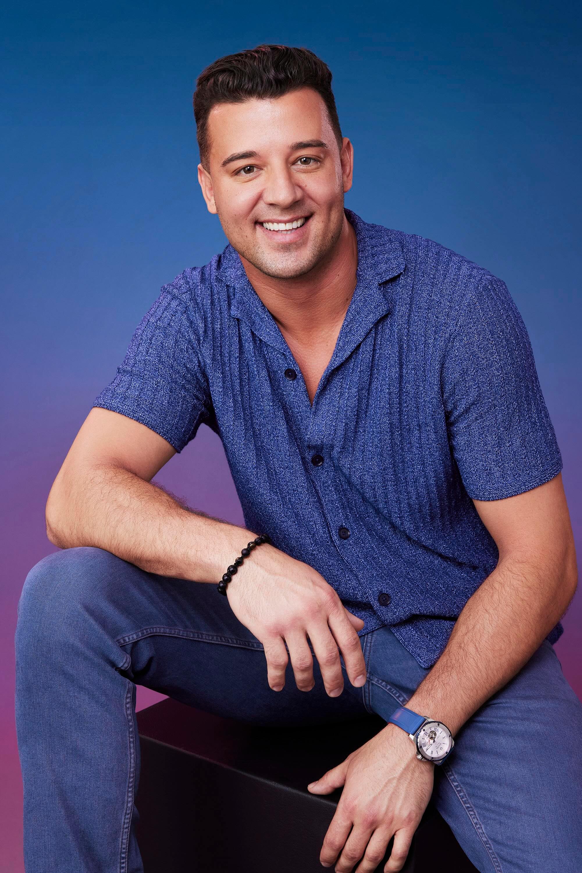 Brian poses in front of a blue-purple ombré background for his official 'The Bachelorette' Season 21 portrait.