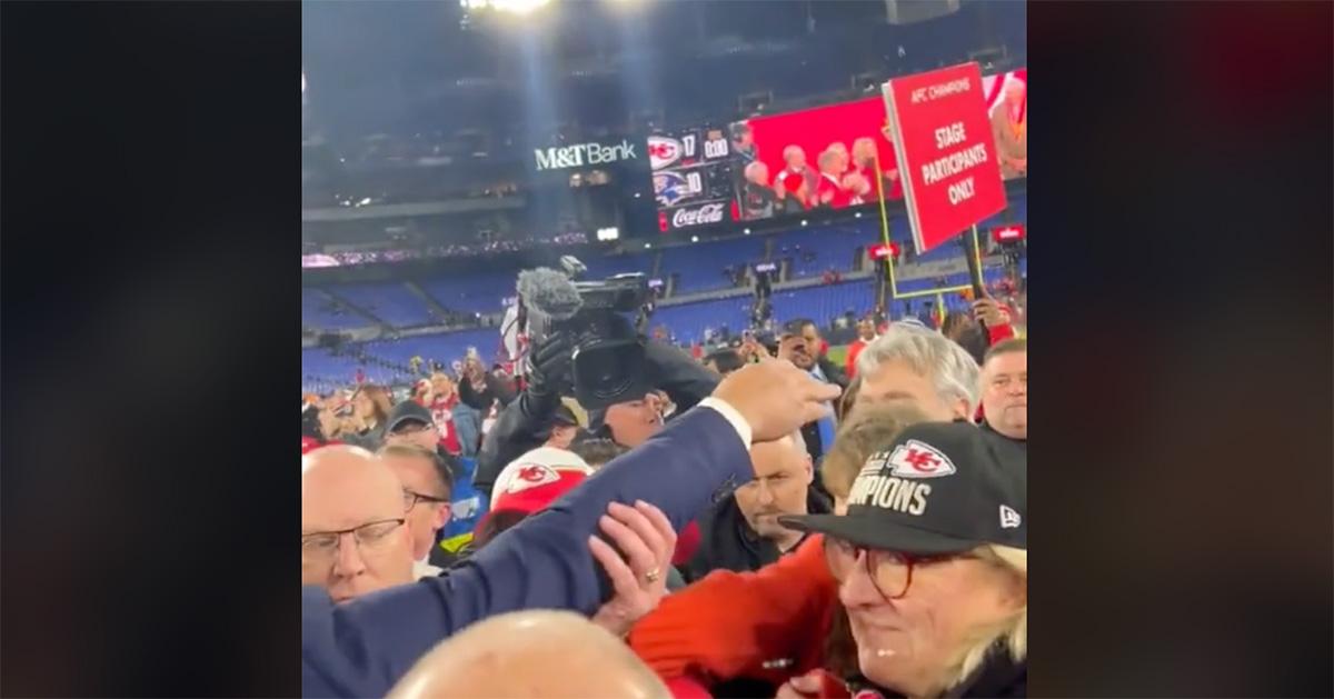 A security guard intercepting Tony Romo's hand as he tries to hug Taylor Swift. 