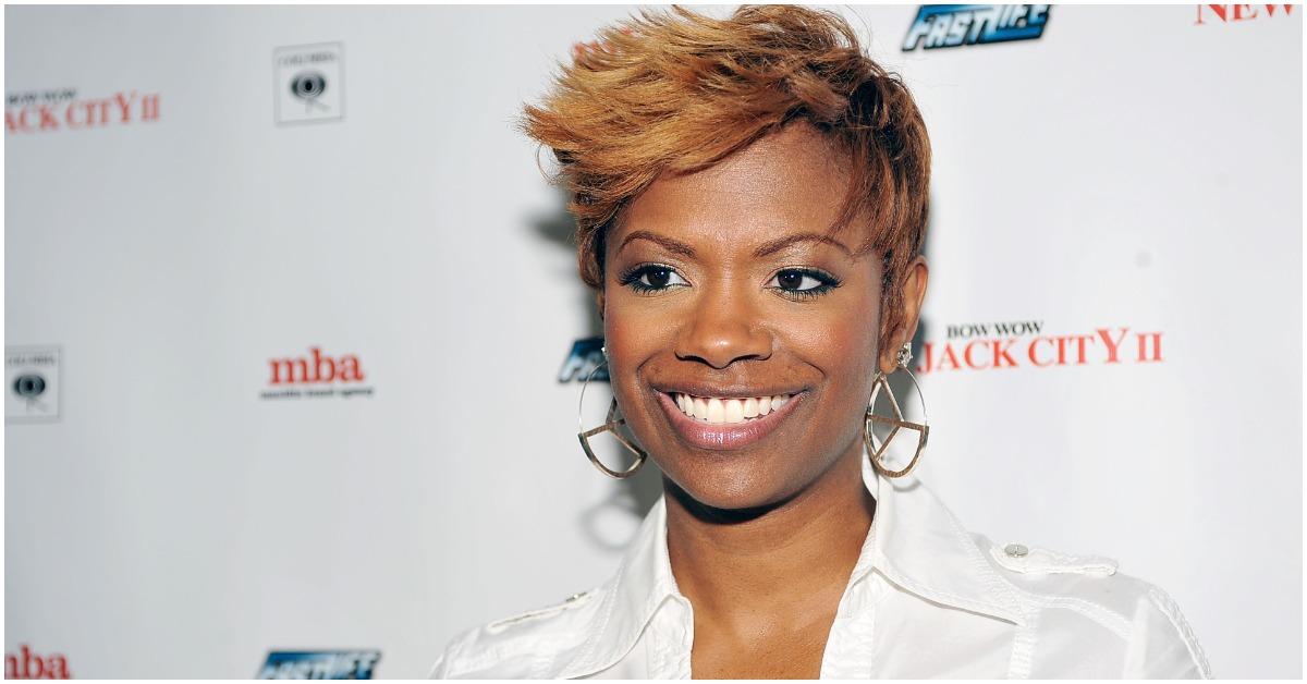 Kandi Burruss smiling while attending a red carpet event.