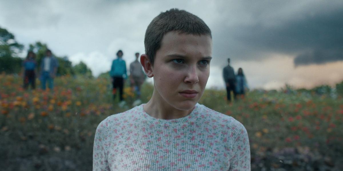 Eleven stands in a field in Stranger Things