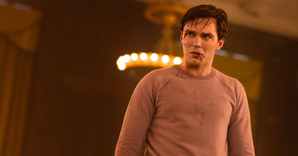 Renfield (Nicholas Hoult) with blood on his face and pink-colored sweater.