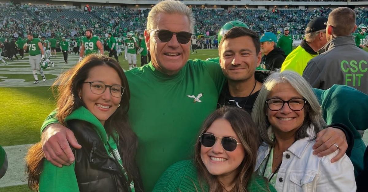 Jeff Stoutland with his family on a football field sidelines.