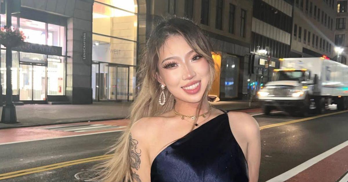 Nina Lin in a dress on a city street with a truck behind her. 